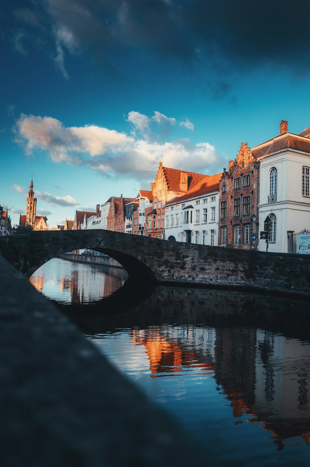 a bridge over a body of water with buildings in the background