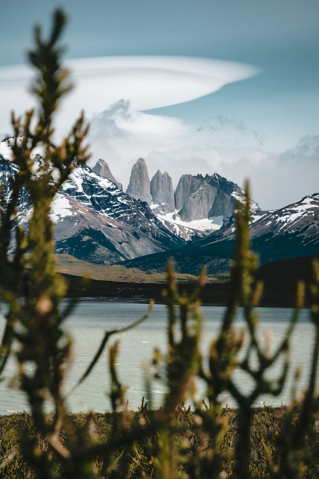 Snow-capped mountains rise behind a calm lake