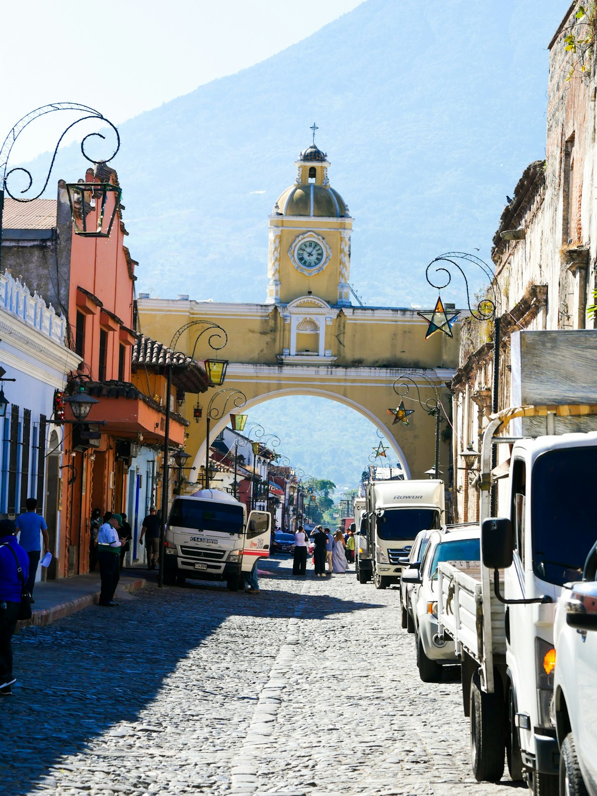 Cobblestone street leading to an archway with a clock tower