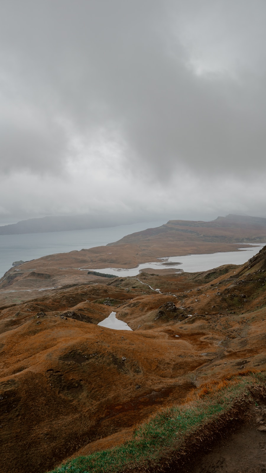 A grassy hill with a body of water in the distance