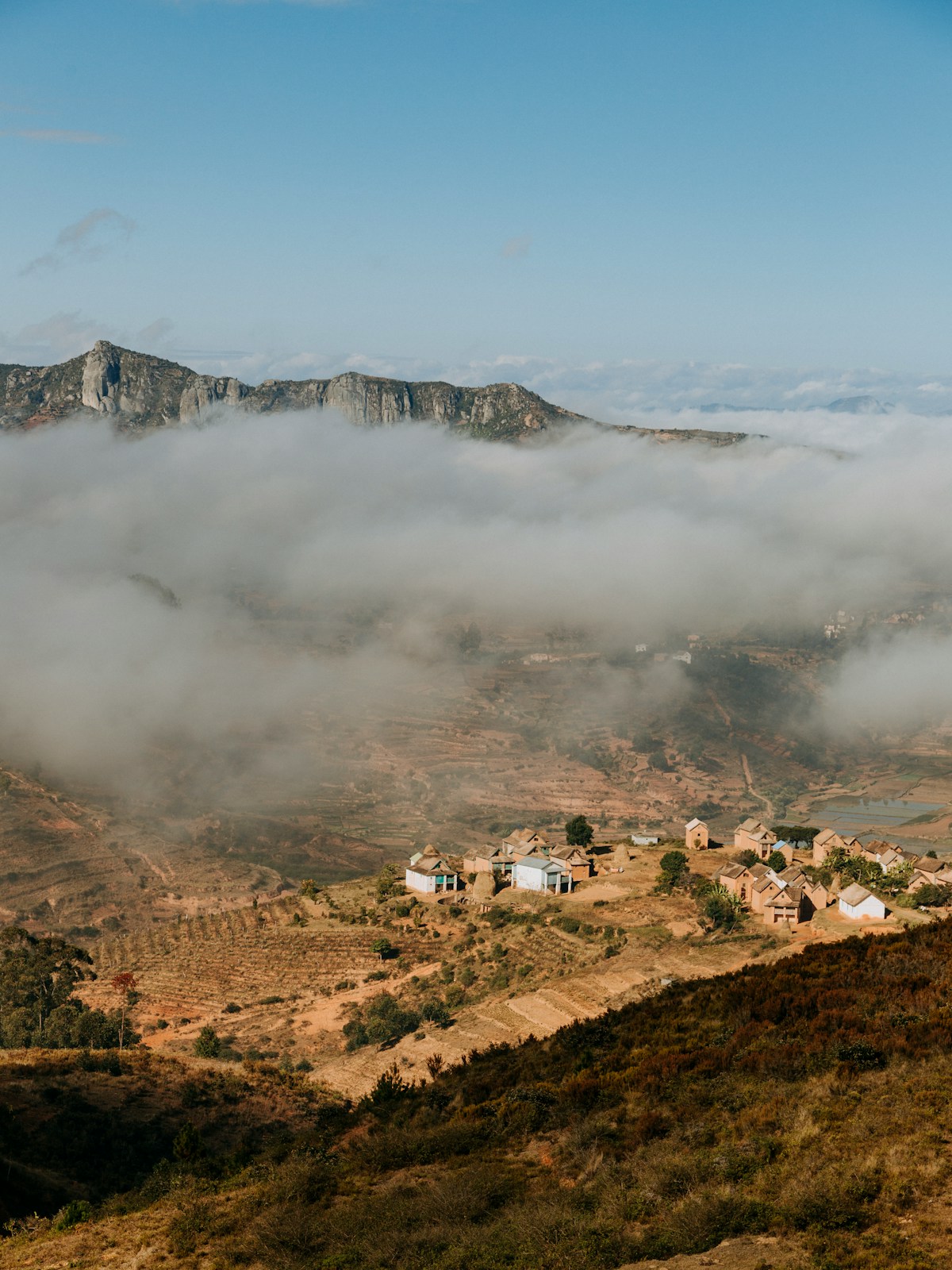 a view of a mountain with a few houses in the foreground