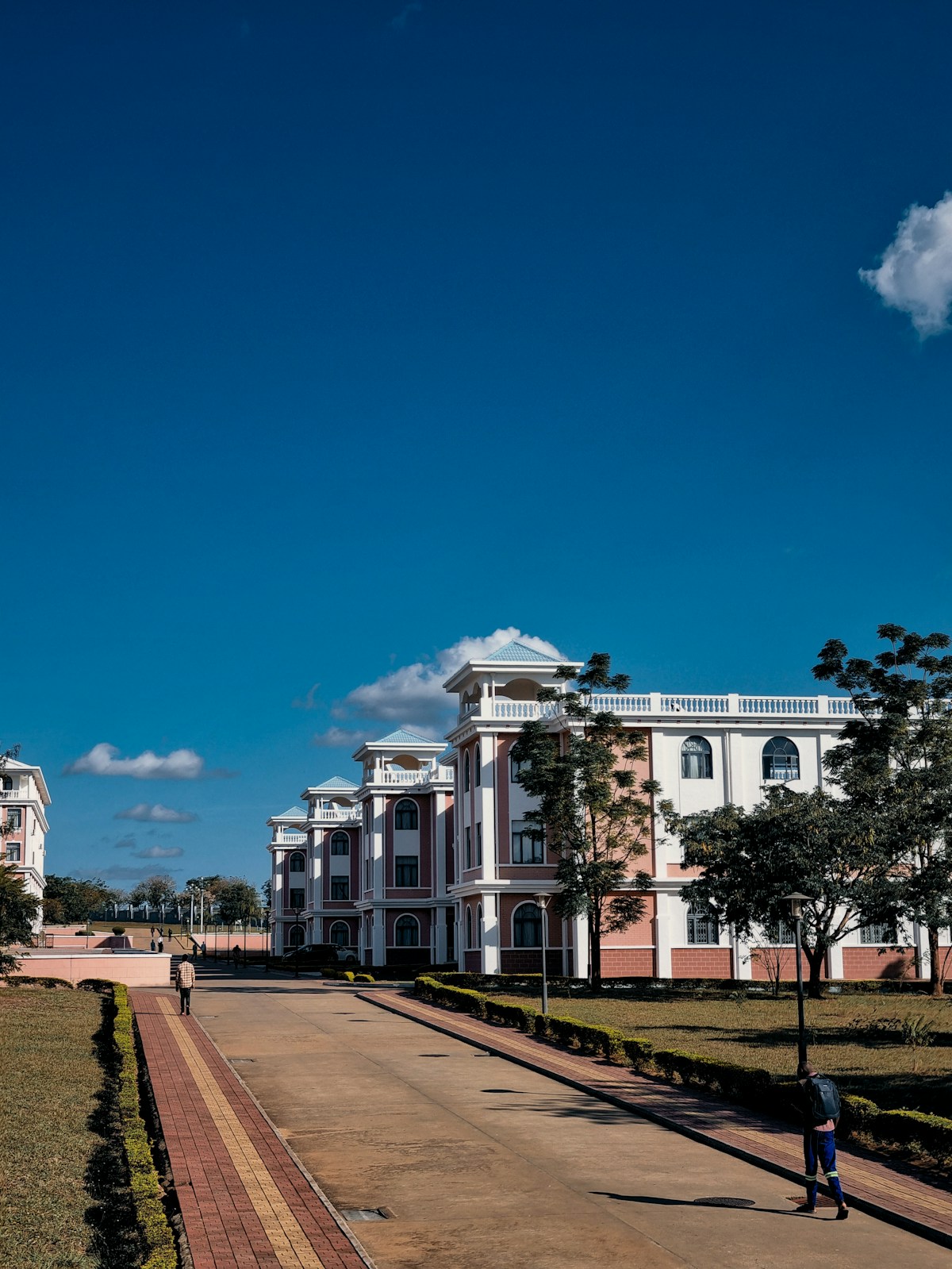 A person walking down a sidewalk in front of a building