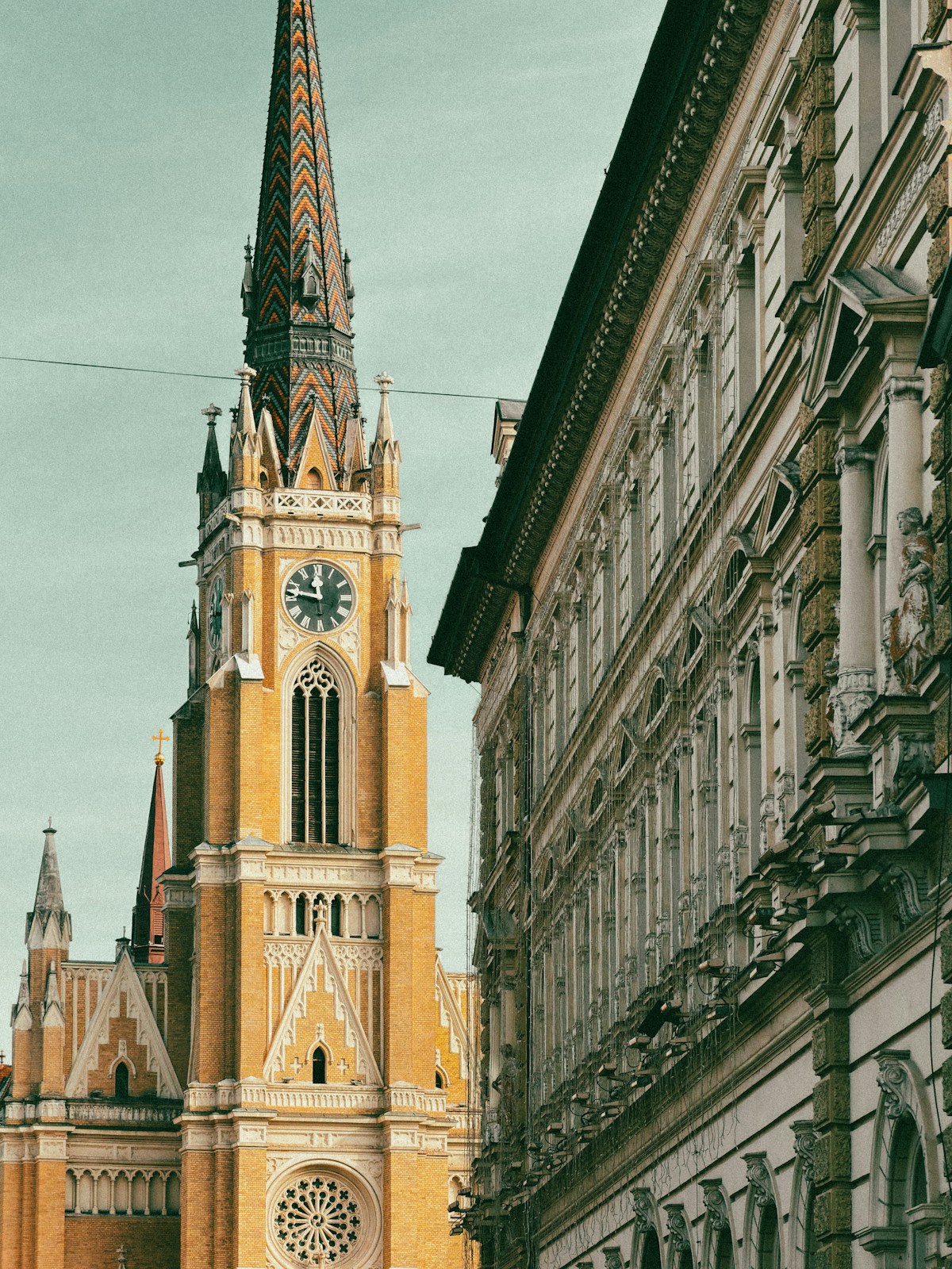 Tall yellow church with a clock tower and ornate building