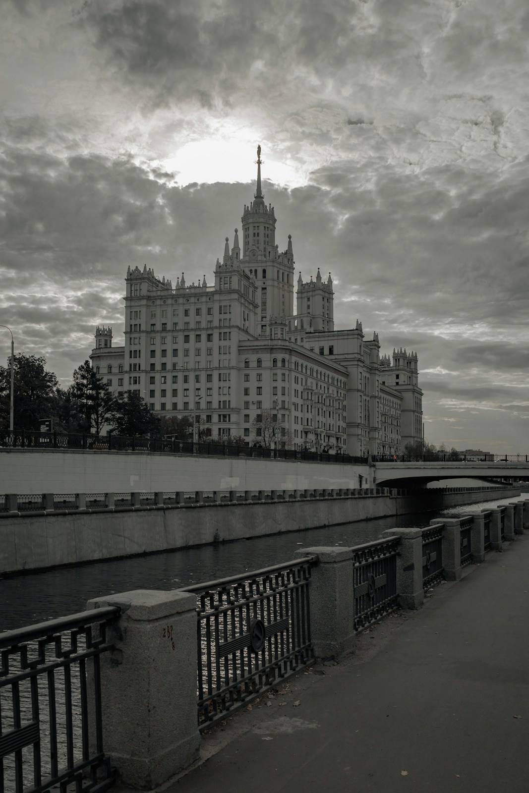 Grand building beside river under cloudy sky