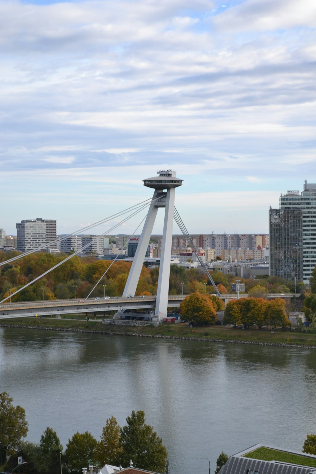 A bridge with a tower over a river and city