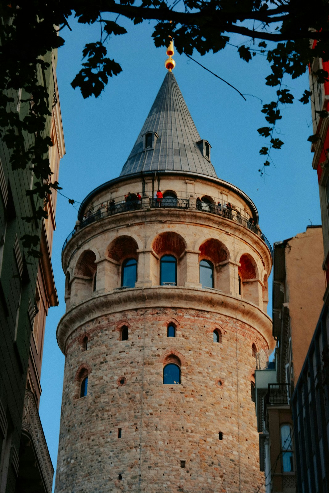 Historic galata tower framed by surrounding buildings and blue sky
