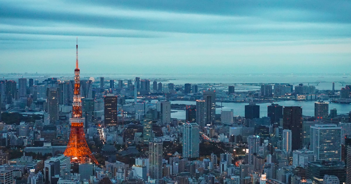 tokyo tower illuminated at dusk with city skyline