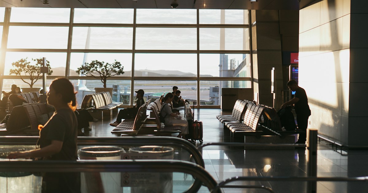 a man sitting in an airport waiting for his luggage